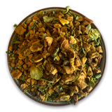 Teeschale gefüllt mit unserem 'Abendkräutertee', der unter anderem Apfelstückchen, Hopfenblüten und Zitronenverbene enthält. Ein wohltuender Tee für entspannte Abende.