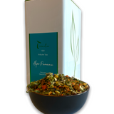 Teedose mit blauem Etikett und Teeschlae mit Kräutertee 'Alpenpanorama' in der Frontalansicht