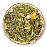 Eine Teeschale mit dem Trockenprodukt des Morning Melodie Bio, bestehend aus grünem Tee, weißem Tee, Rosenblüten, Ringelblumen und Kornblumen
