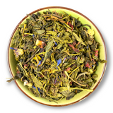 Eine Teeschale mit dem Trockenprodukt des Melodie Bio, bestehend aus Oolong-Tee, Granatapfelstücken, Hibiscus und blauen Kornblumen