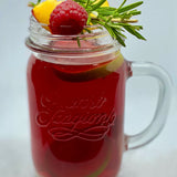 Zu sehen ist ein Eisteeglas mit dem fertigen Früchtetee und einer Dekoration aus Himbeeren, Rosmarin und Pfirsisch
